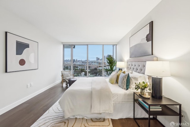 bedroom featuring dark wood-type flooring and floor to ceiling windows