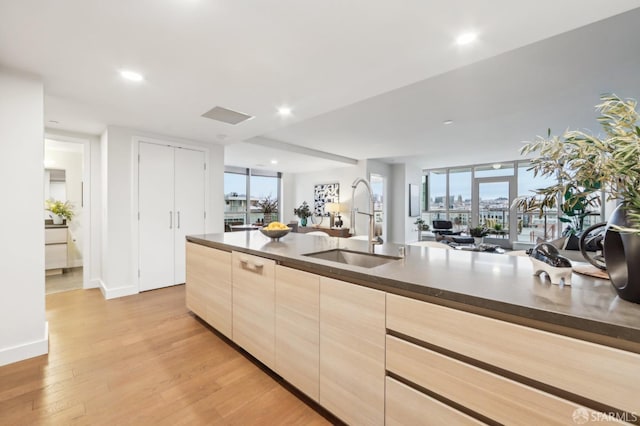 kitchen with sink, light brown cabinetry, and light hardwood / wood-style floors