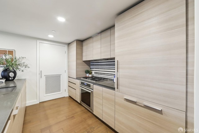 kitchen with appliances with stainless steel finishes and light hardwood / wood-style floors