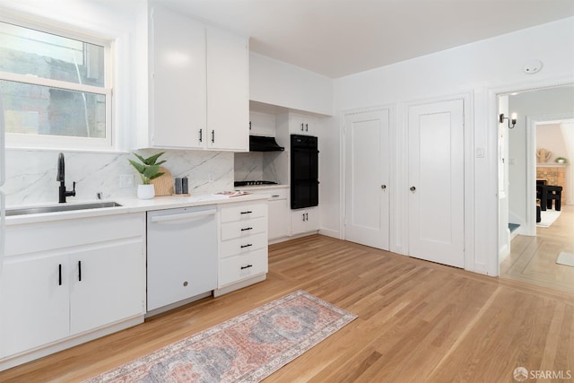 651 29th Ave, San Francisco, CA 94121 - kitchen featuring white dishwasher, a sink, light countertops, white cabinetry, and light wood-style flooring