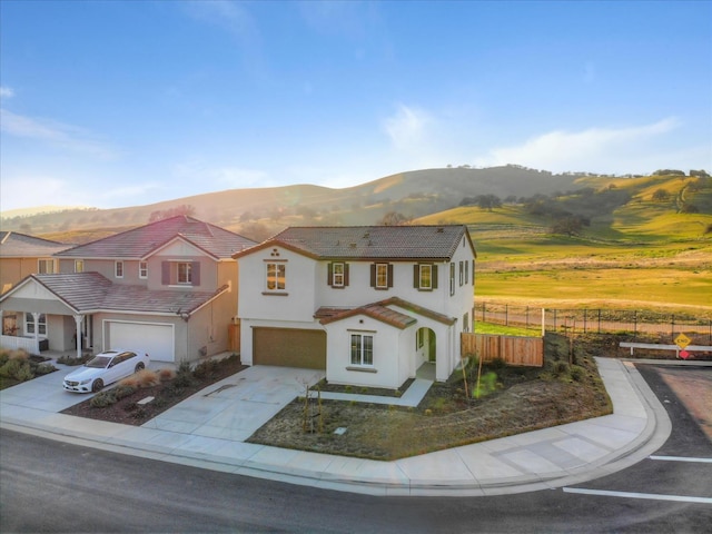 21051 Pinot Noir Dr, Patterson, CA 95363 - mediterranean / spanish home with fence, an attached garage, a mountain view, driveway, and a tiled roof