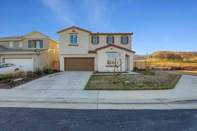 21051 Pinot Noir Dr, Patterson, CA 95363 - mediterranean / spanish house with fence, a garage, a tiled roof, stucco siding, and driveway