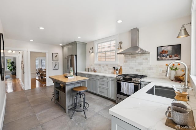 57 Theresa St, San Francisco, CA 94112 - kitchen featuring stainless steel appliances, wall chimney exhaust hood, gray cabinetry, light stone counters, and recessed lighting