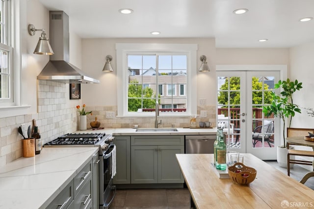 57 Theresa St, San Francisco, CA 94112 - kitchen featuring wall chimney exhaust hood, stainless steel appliances, recessed lighting, tasteful backsplash, and french doors