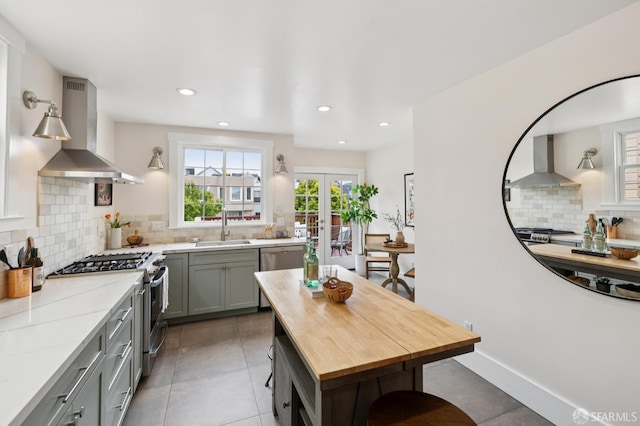 57 Theresa St, San Francisco, CA 94112 - kitchen featuring wall chimney range hood, appliances with stainless steel finishes, gray cabinets, tasteful backsplash, and recessed lighting