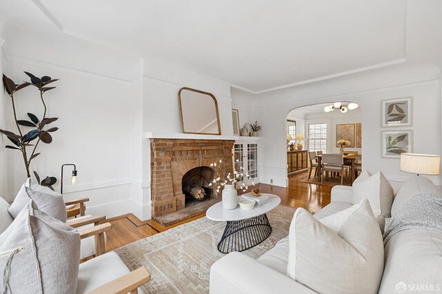 57 Theresa St, San Francisco, CA 94112 - living area featuring arched walkways, wood finished floors, a brick fireplace, and a chandelier