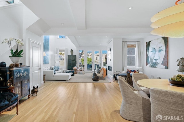 interior space with french doors, beamed ceiling, and light wood-type flooring