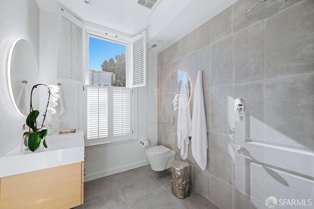 bathroom featuring vanity, tile patterned floors, a healthy amount of sunlight, and walk in shower