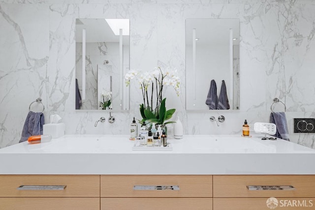 bathroom with vanity and tile walls