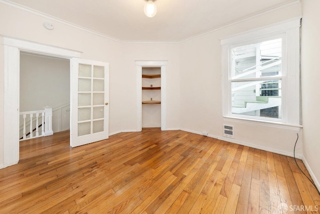 spare room featuring wood-type flooring and ornamental molding