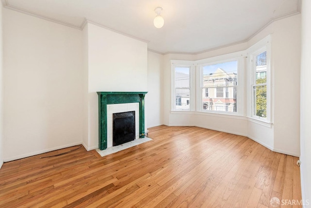 unfurnished living room with ornamental molding and light hardwood / wood-style flooring