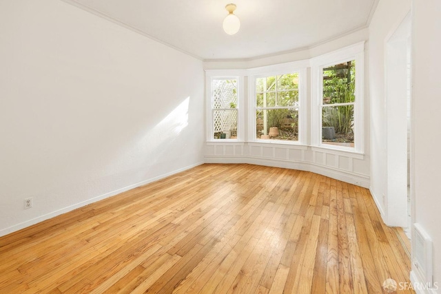 unfurnished room featuring crown molding and light hardwood / wood-style floors