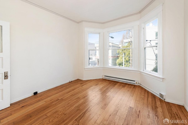 spare room featuring crown molding, light hardwood / wood-style floors, and a baseboard radiator