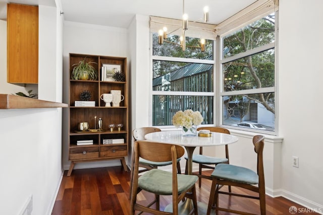 dining space featuring an inviting chandelier, baseboards, and dark wood-style flooring