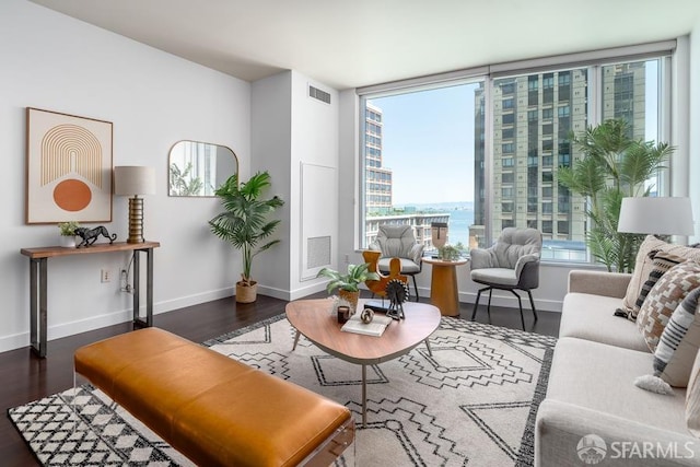 living room featuring visible vents, baseboards, and wood finished floors