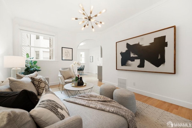 24 Magnolia St, San Francisco, CA 94123 - living area featuring arched walkways, a chandelier, light wood finished floors, ornamental molding, and baseboards