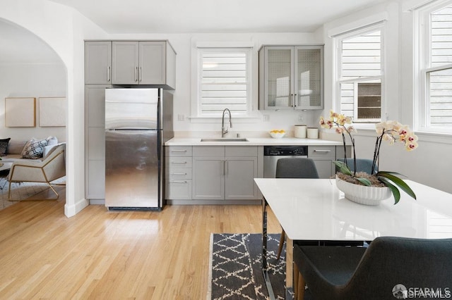 24 Magnolia St, San Francisco, CA 94123 - kitchen with appliances with stainless steel finishes, gray cabinetry, a sink, and light wood-style floors