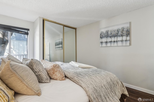 1140 Whipple Ave Unit 21, Redwood City, CA 94062 - bedroom with dark wood-style flooring, baseboards, a textured ceiling, and a closet