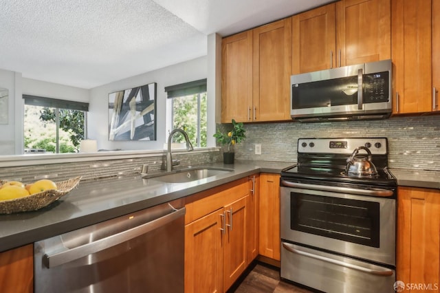 1140 Whipple Ave Unit 21, Redwood City, CA 94062 - kitchen with stainless steel appliances, a sink, plenty of natural light, brown cabinets, and a textured ceiling