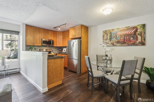 1140 Whipple Ave Unit 21, Redwood City, CA 94062 - kitchen featuring stainless steel appliances, a textured ceiling, dark wood-style floors, track lighting, and a baseboard radiator