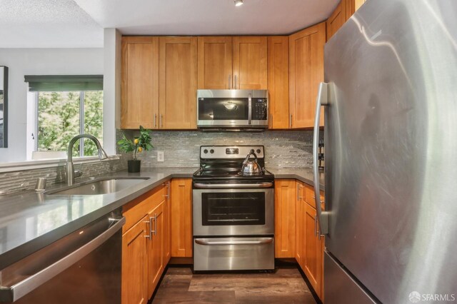1140 Whipple Ave Unit 21, Redwood City, CA 94062 - kitchen with appliances with stainless steel finishes, a sink, dark wood-style flooring, tasteful backsplash, and brown cabinetry