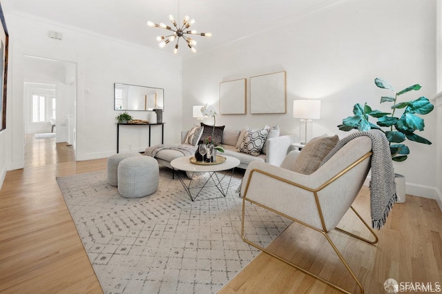 living room featuring baseboards, light wood finished floors, an inviting chandelier, and crown molding