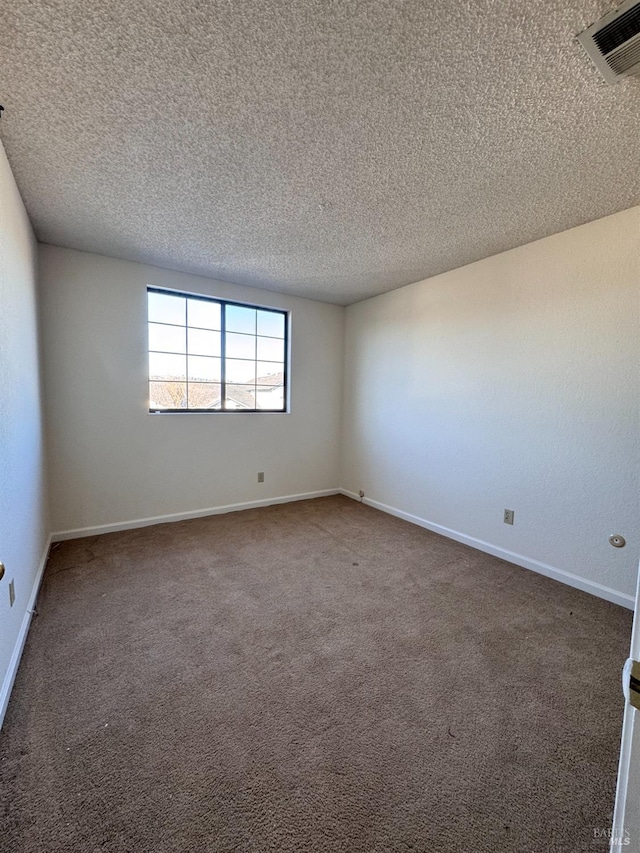 spare room with dark carpet and a textured ceiling