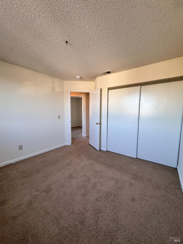 unfurnished bedroom with carpet flooring, a closet, and a textured ceiling