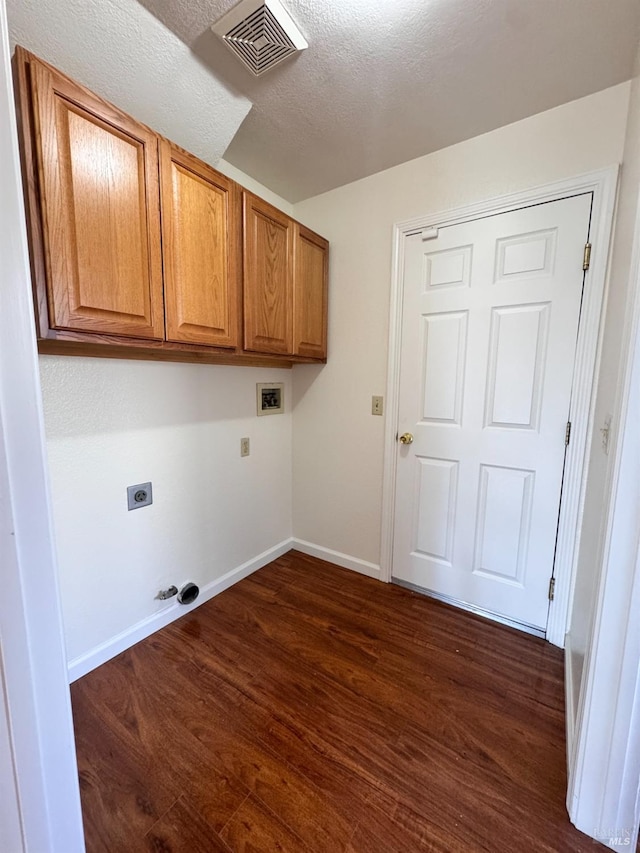 washroom with electric dryer hookup, cabinets, dark hardwood / wood-style floors, washer hookup, and a textured ceiling