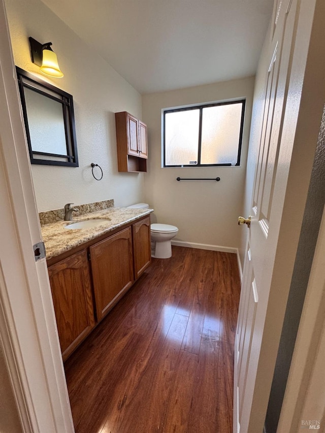 bathroom featuring vanity, hardwood / wood-style floors, and toilet