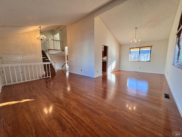 unfurnished living room featuring vaulted ceiling, a textured ceiling, a notable chandelier, and dark hardwood / wood-style flooring