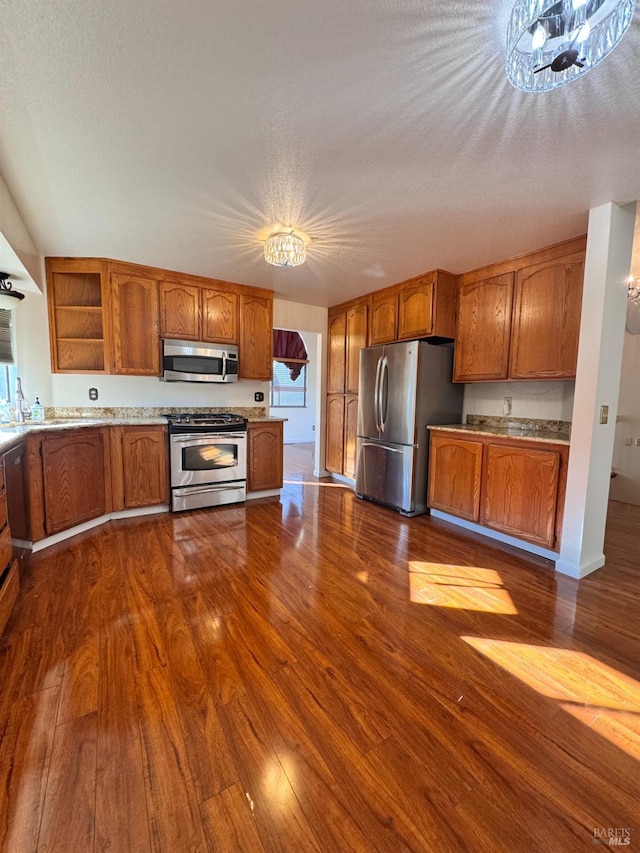 kitchen featuring stainless steel appliances, dark hardwood / wood-style floors, and a textured ceiling