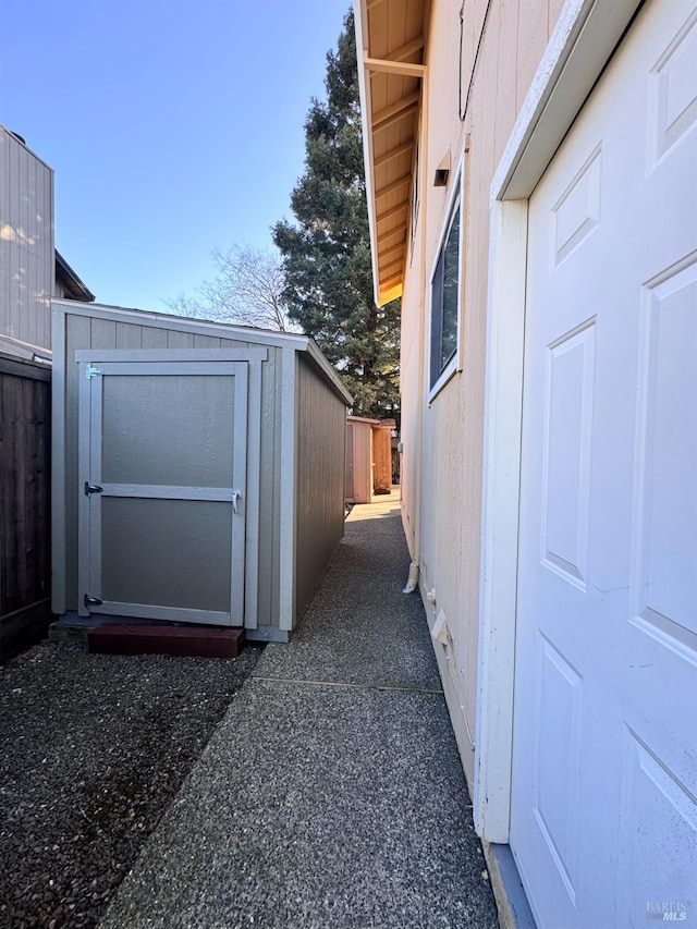 view of property exterior with a storage unit