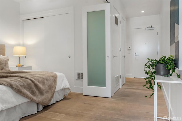 bedroom with light hardwood / wood-style floors and a closet