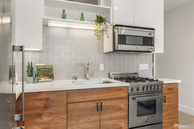 kitchen featuring white cabinetry, sink, decorative backsplash, and appliances with stainless steel finishes