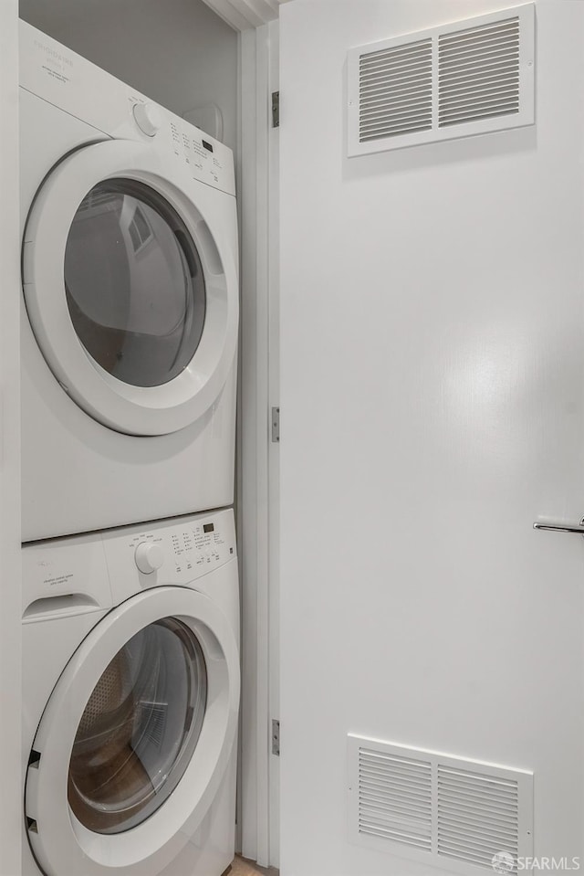 washroom featuring stacked washing maching and dryer