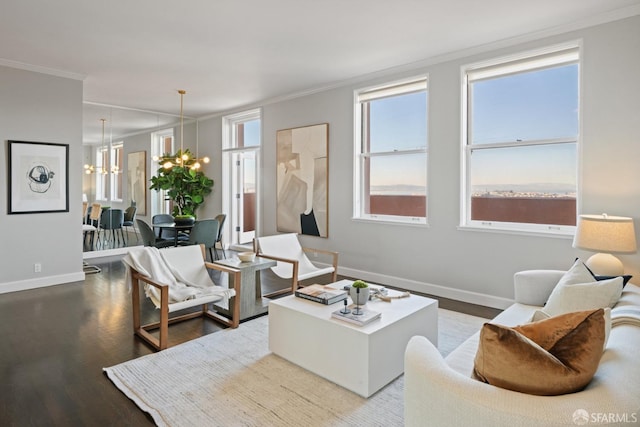 living room featuring hardwood / wood-style floors, an inviting chandelier, and ornamental molding