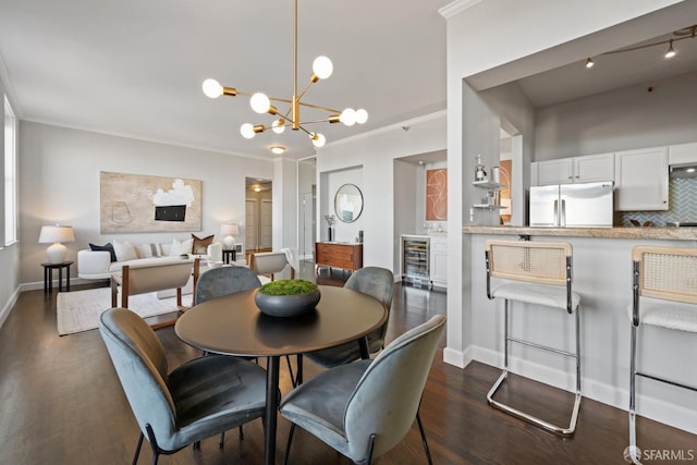 dining room with a notable chandelier, dark hardwood / wood-style floors, beverage cooler, and ornamental molding