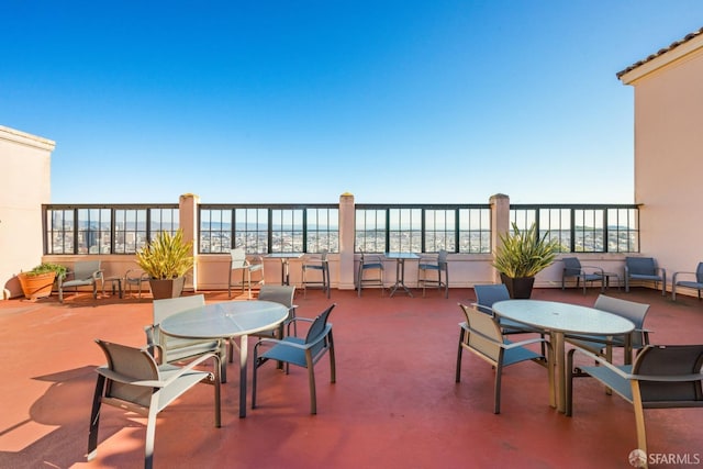 view of patio / terrace featuring a water view and a beach view