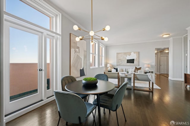 dining space featuring a chandelier, dark hardwood / wood-style floors, a wealth of natural light, and ornamental molding