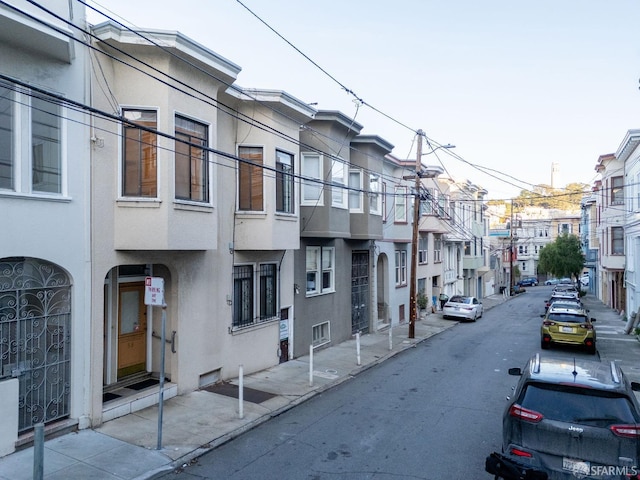 view of street with street lighting, a residential view, curbs, and sidewalks