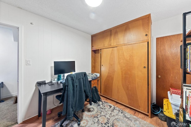 home office with a textured ceiling and wood finished floors