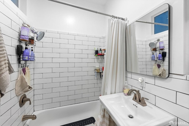 full bath with a sink, tile walls, and shower / tub combo with curtain