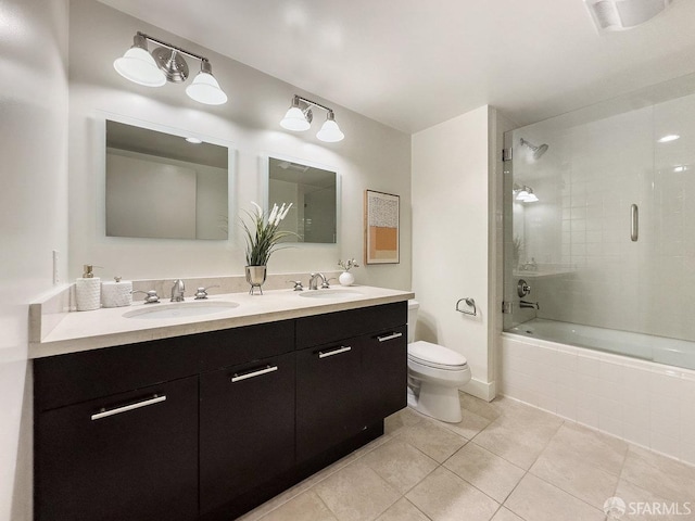 full bathroom featuring tile patterned flooring, shower / bath combination with glass door, vanity, and toilet