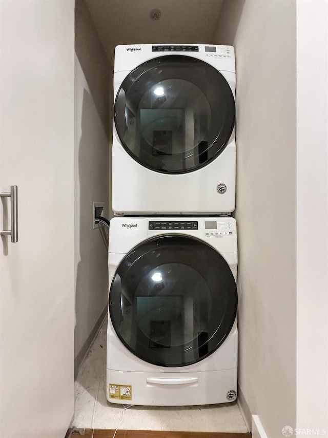 clothes washing area featuring stacked washer and clothes dryer