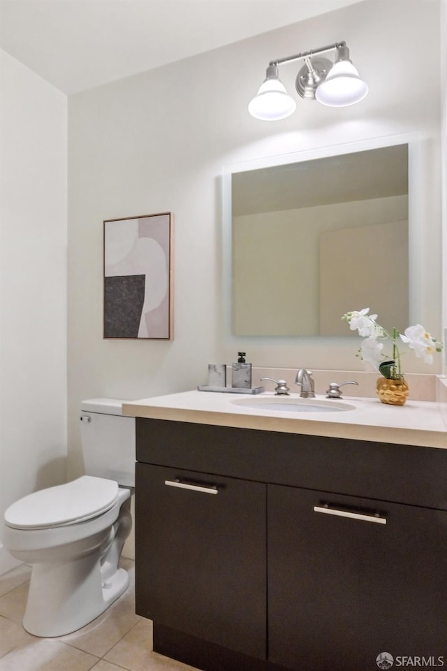 bathroom with tile patterned flooring, vanity, and toilet