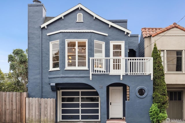 view of front of property featuring a balcony and a garage