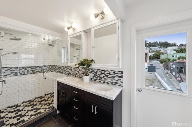 bathroom featuring vanity, decorative backsplash, tile patterned floors, and walk in shower