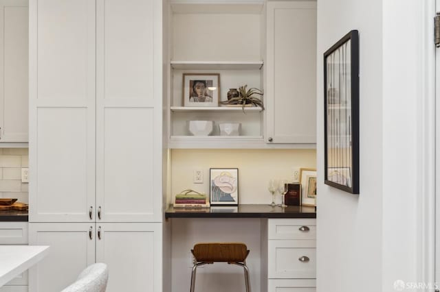 bar featuring built in desk and white cabinets