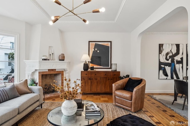 living room featuring an inviting chandelier, parquet floors, and a tile fireplace